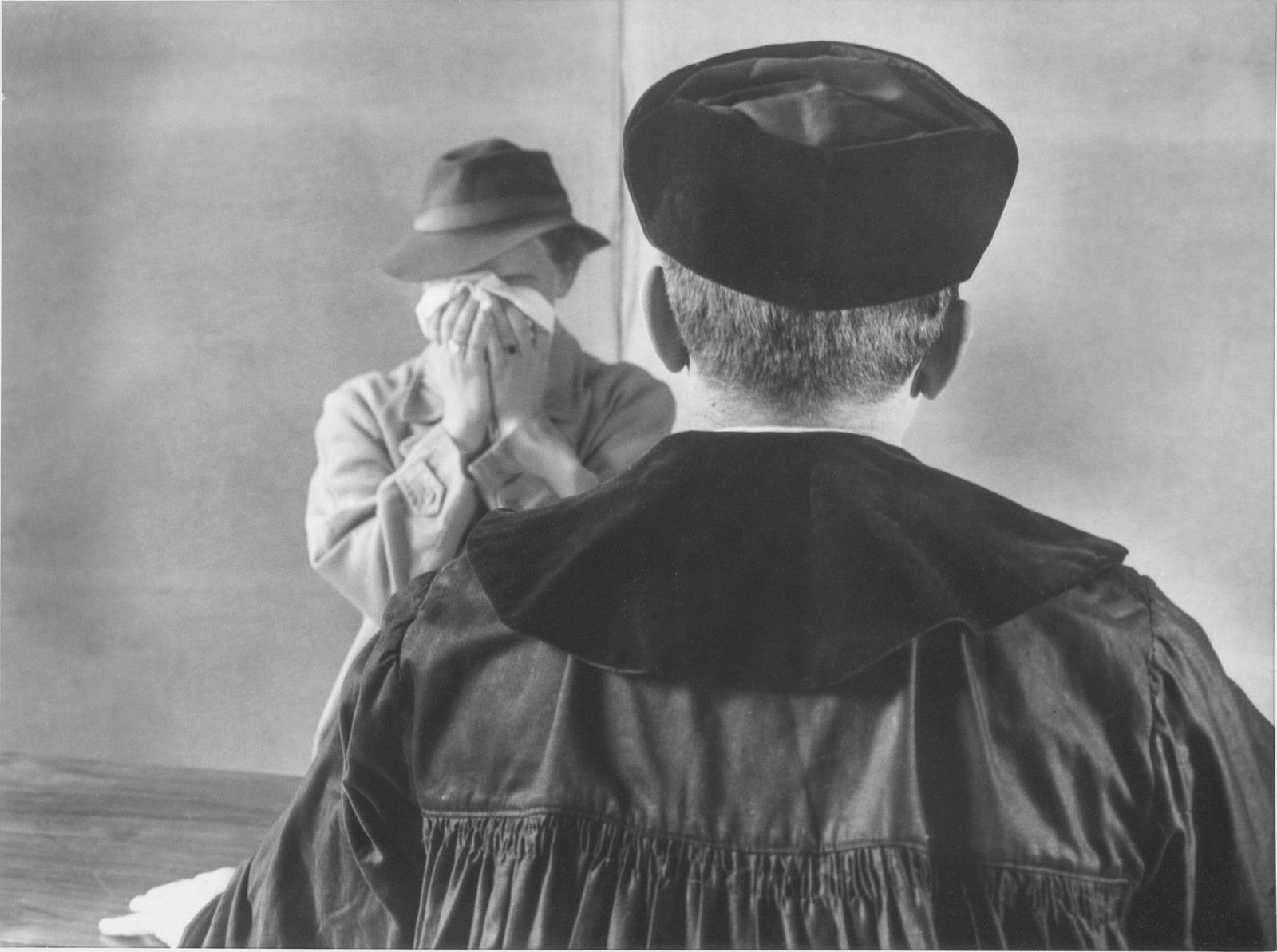 Richter im Talar mit Barett und eine Person mit Taschentuch, von hinten gesehen — Fotografie von Elisabeth Hase
